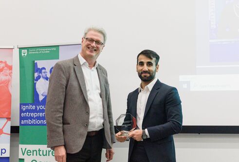 Man presenting an award to a student
