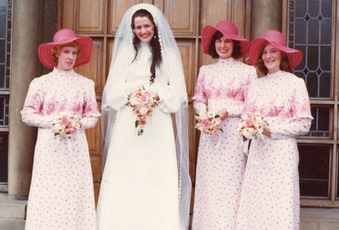 1974 wedding photo of Anne Kendall standing on the front steps of a building with her bridesmaids
