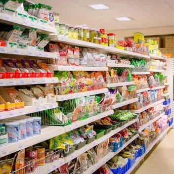 student looking along supermarket shelves