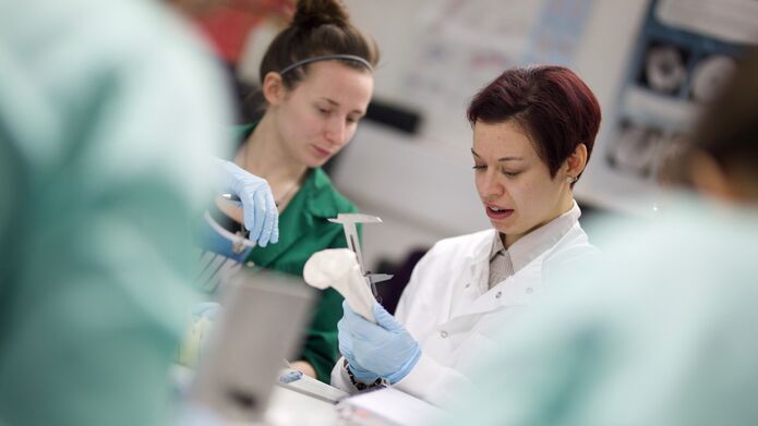 2 people in a lab looking at bones
