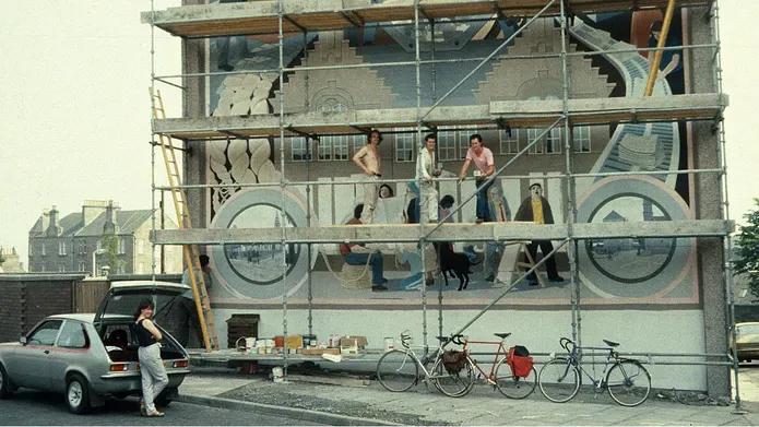 Painters decorating the gable end of a building in the 1980s