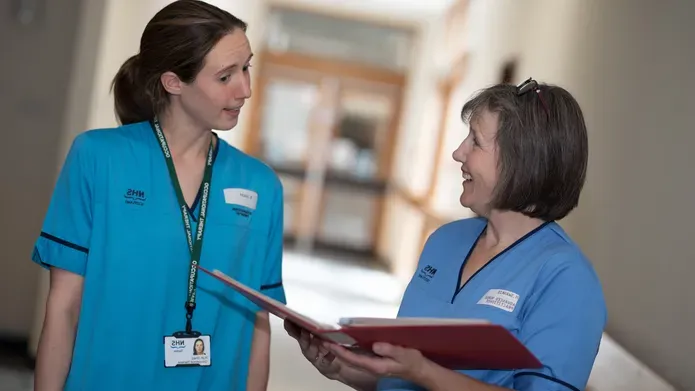 two nurses talking in a corridor