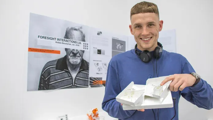 Robbie Beautymean holding his work