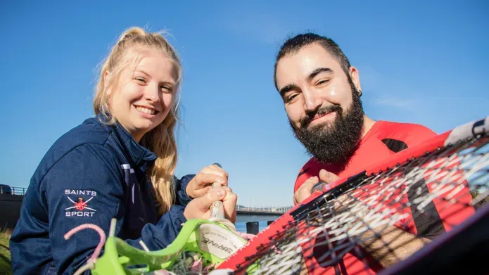 Grinning students from the Universities of Dundee and St Andrews brandish racquets at the camera