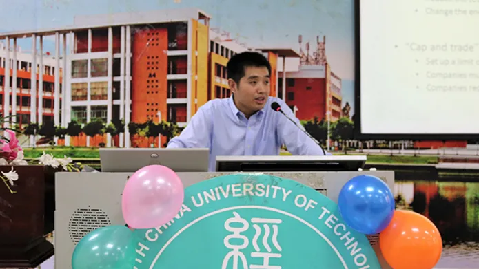 Dr Mu giving a talk at a podium
