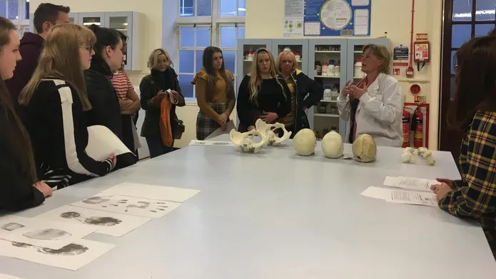 a group of school pupils standing around  table  getting a lesson in anatomy