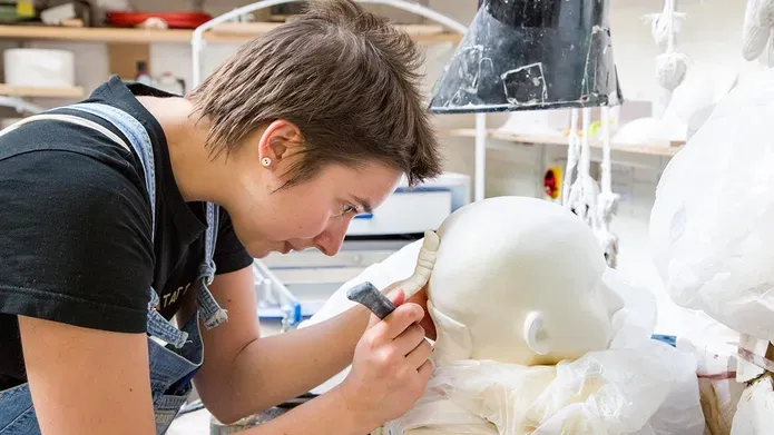 a student working in a ceramic head