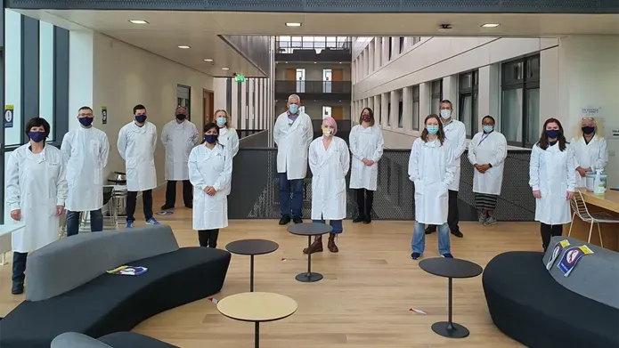 researchers in lab coats and masks