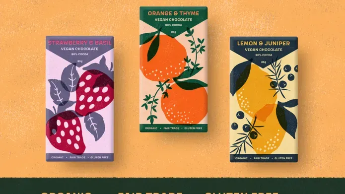Three packages of vegan chocolate with a variety of strawberries, oranges and lemons