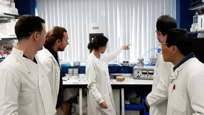 people in lab coats standing in a group in a lab