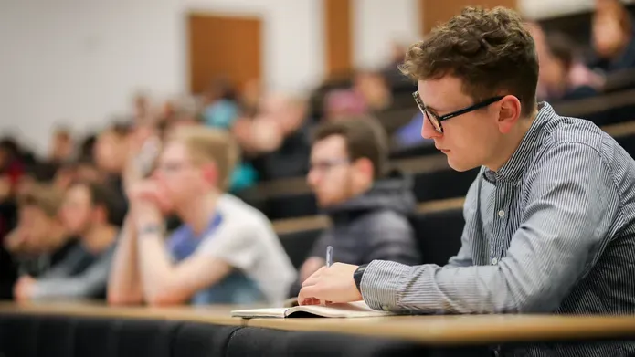 Student taking notes during a lecture