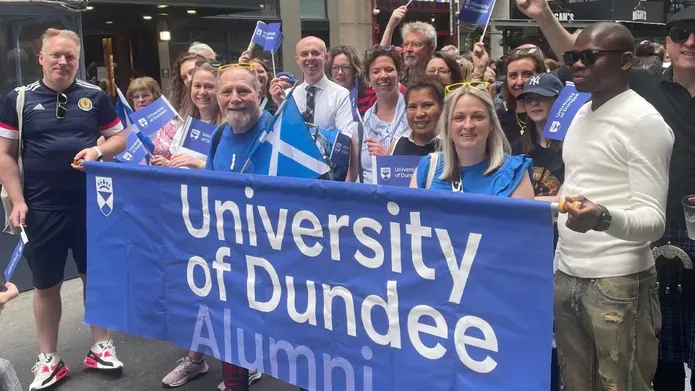 Alumini team holding banner of University of Dundee
