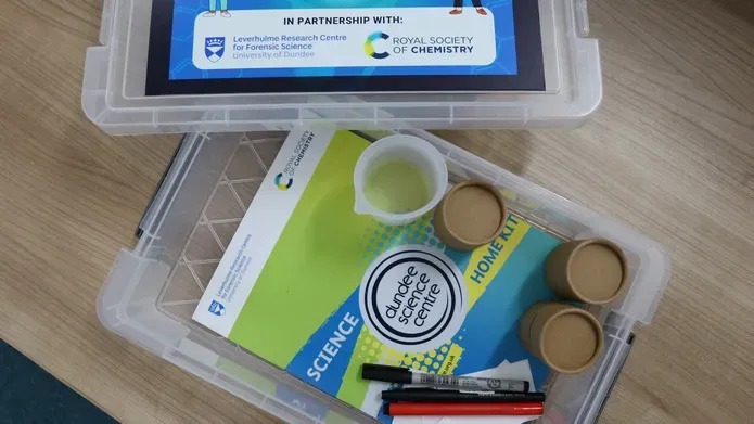 Photo of the forensic chemistry at home kit featuring the booklet and materials that come with the kit