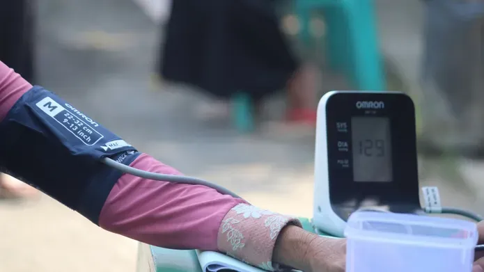 A woman's arm wrapped in blood pressure monitor