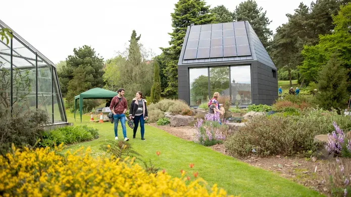 garden with a greenhouse and a path in the centre