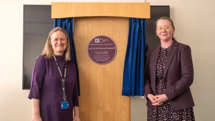 Prof Grunwald and Janet Geddes stand either side of the Purple Plaque presented to Professor Grunwald