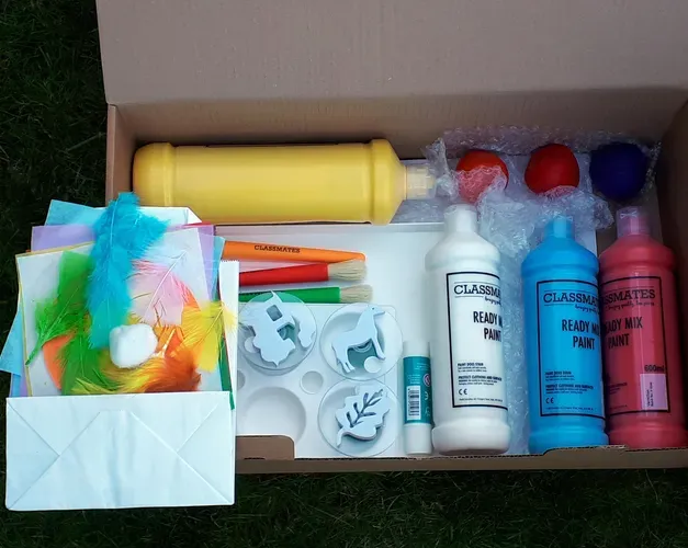 A cardboard box containing bottles of paint