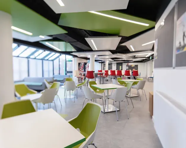 empty cafe space with lots of light and red and green seating