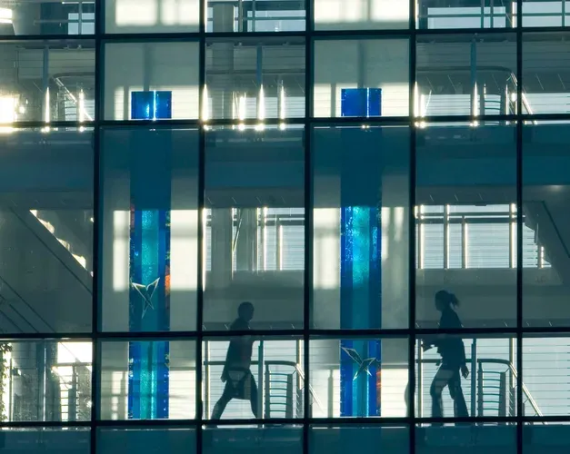 People can be seen through the windows of the Wellcome building.