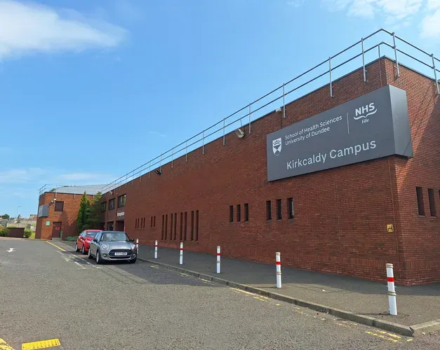 New signage at the entrance to Kirkcaldy campus. The new signage has a grey background with writing on it, and is located above the covered walkway to the building