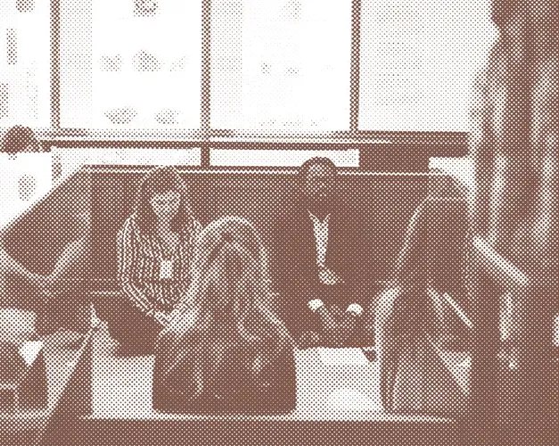 Sepia toned photograph of workshop participants meditating sat on the floor of a museum