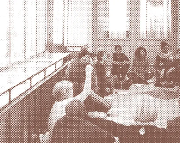 Sepia toned photograph of event with participants sat on floor