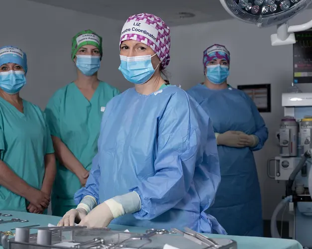surgeons wearing hospital scrubs, masks and hair nets