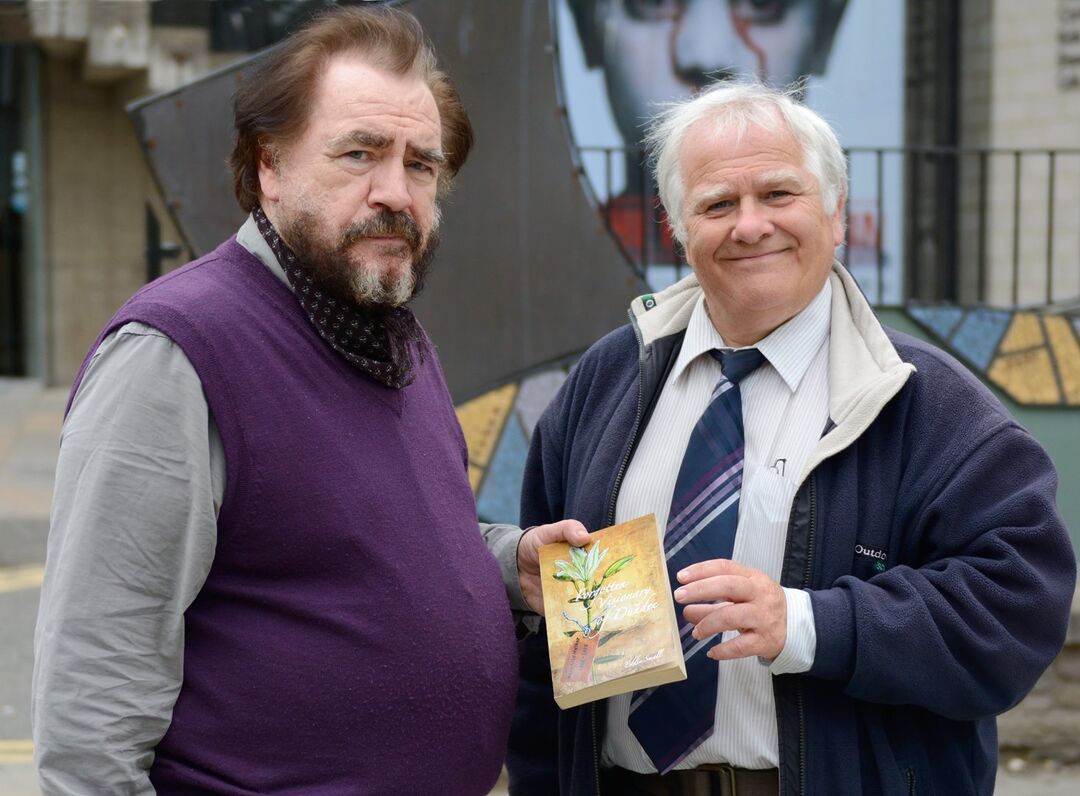 Eddie Small presenting Brian Cox with a copy of his book of Mary Lily Walker