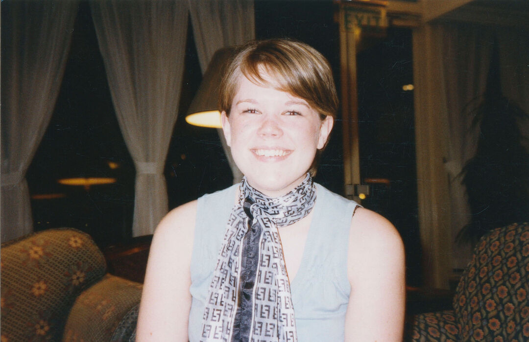 Sheryl Bartlett sits in a soft lit room, with bright light on her face.