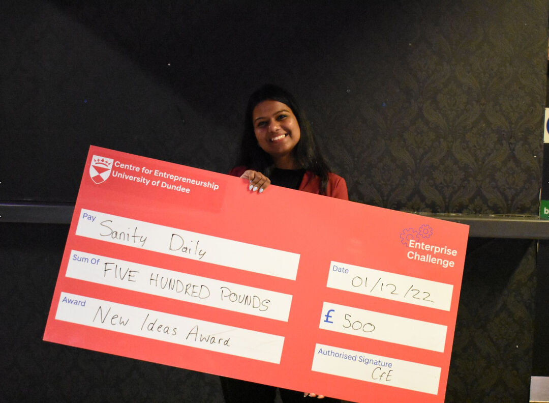 The runner up winner of the New Ideas award holding an oversized cheque showing the value of £500