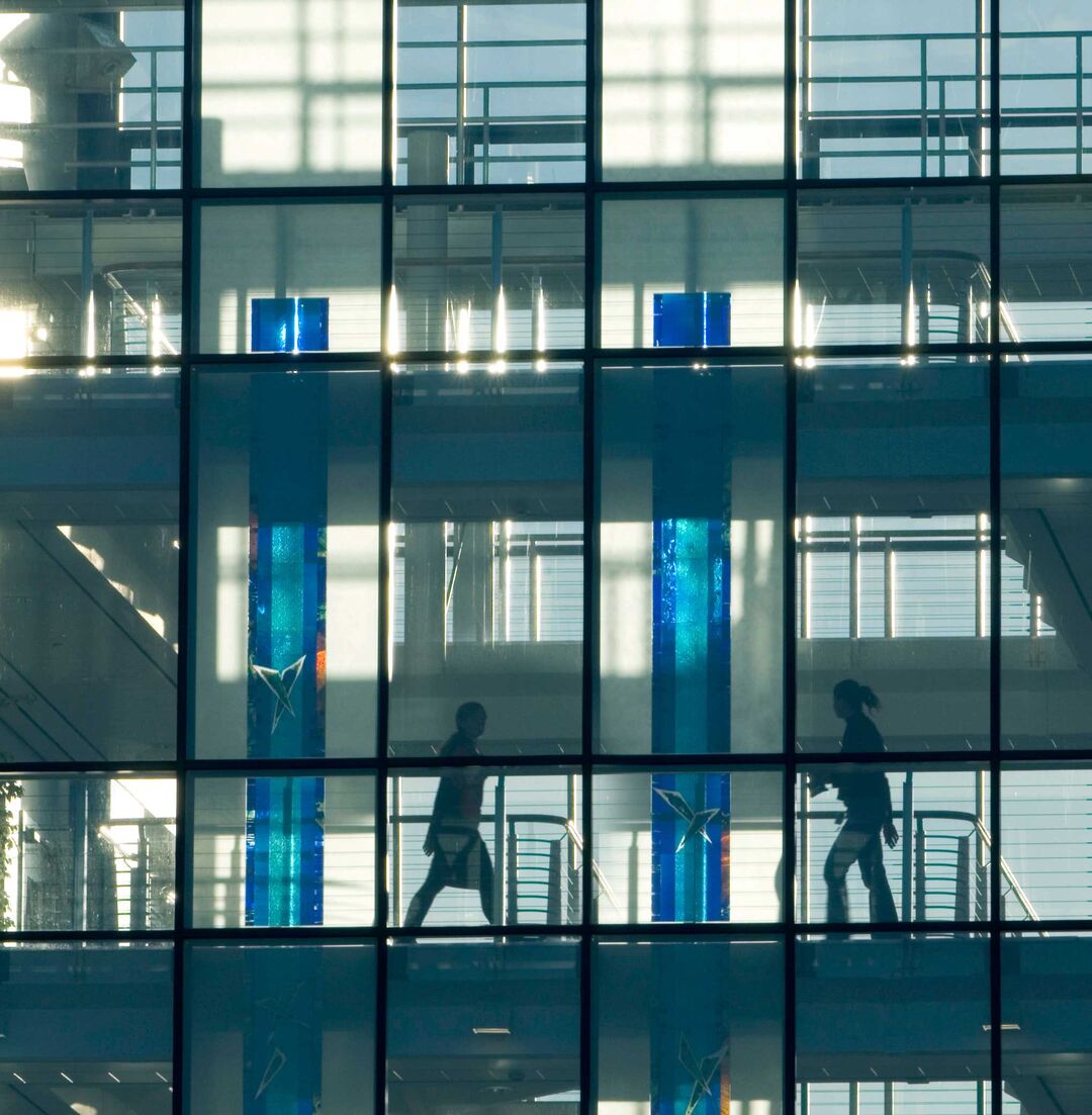 People can be seen through the windows of the Wellcome building.