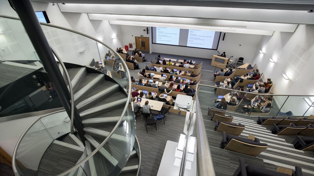 looking down spiral staircase into the lecture theatre, with the front section grouped into collaborative zones