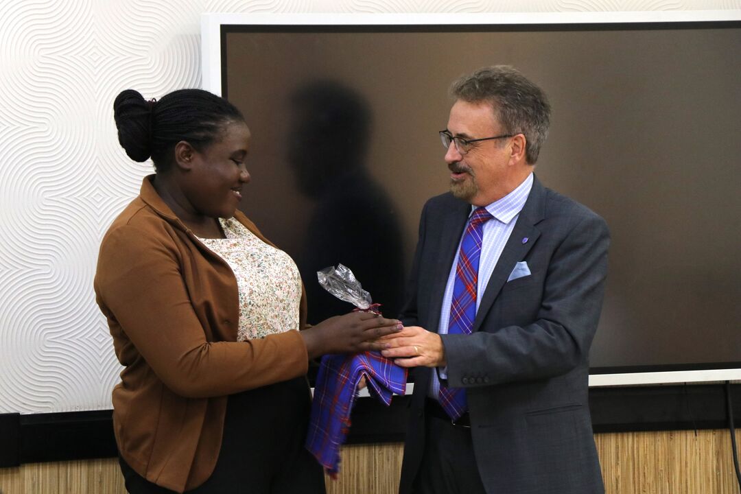 an adf scholar receiving a gift from professor iain gillespie