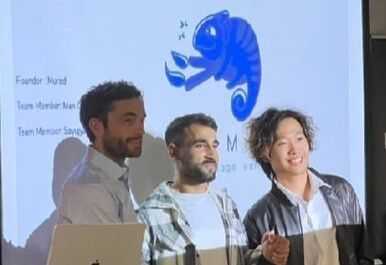 Three people standing in front front of a screen, presenting.