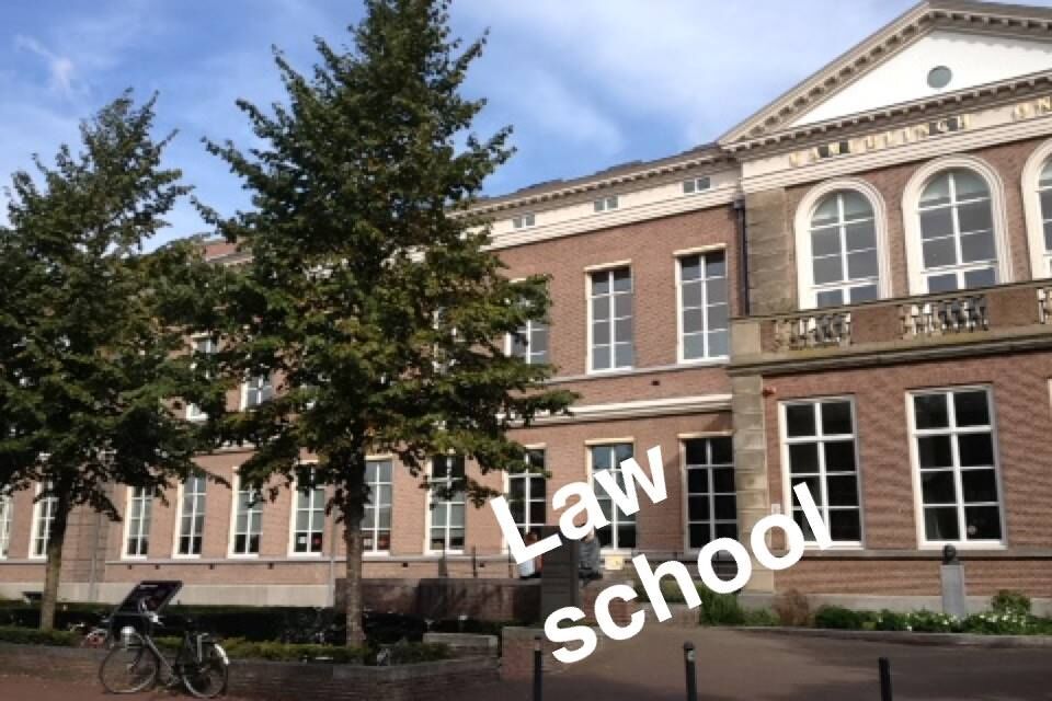 A light brown two storey building. Two trees appear on the left hand side of the image. The words Law School is on the image. This appears to have been taken from social media