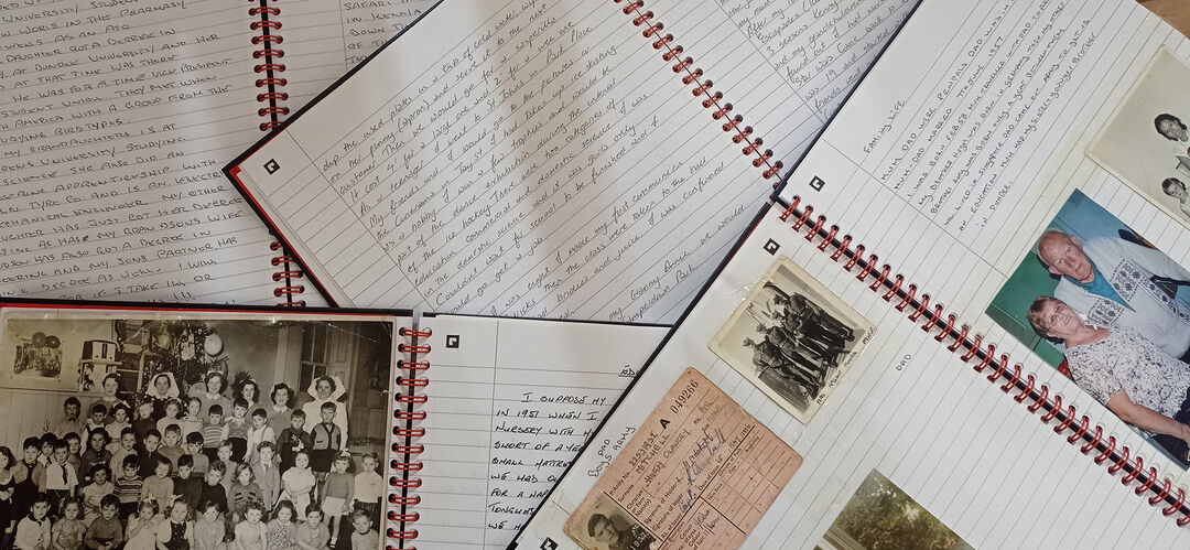 A pile of hand written books with photos