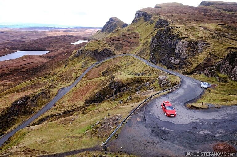 car on windy road through mountain country