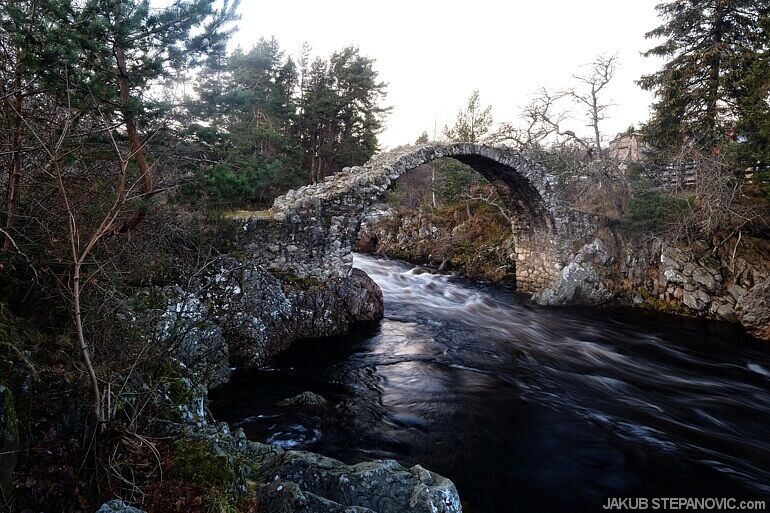 old humpback bridge over river