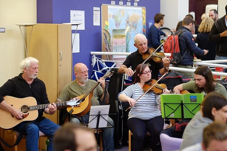 group of people playing guitars and violins