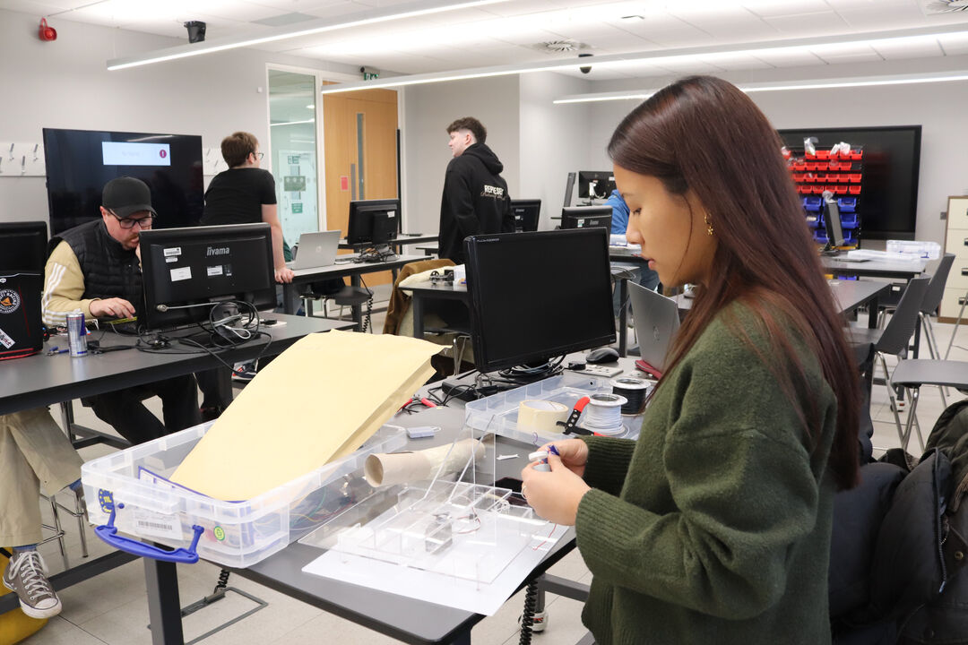 Group of undergraduate mechanical engineering at the University of Dundee students working on lab testing PCBs.