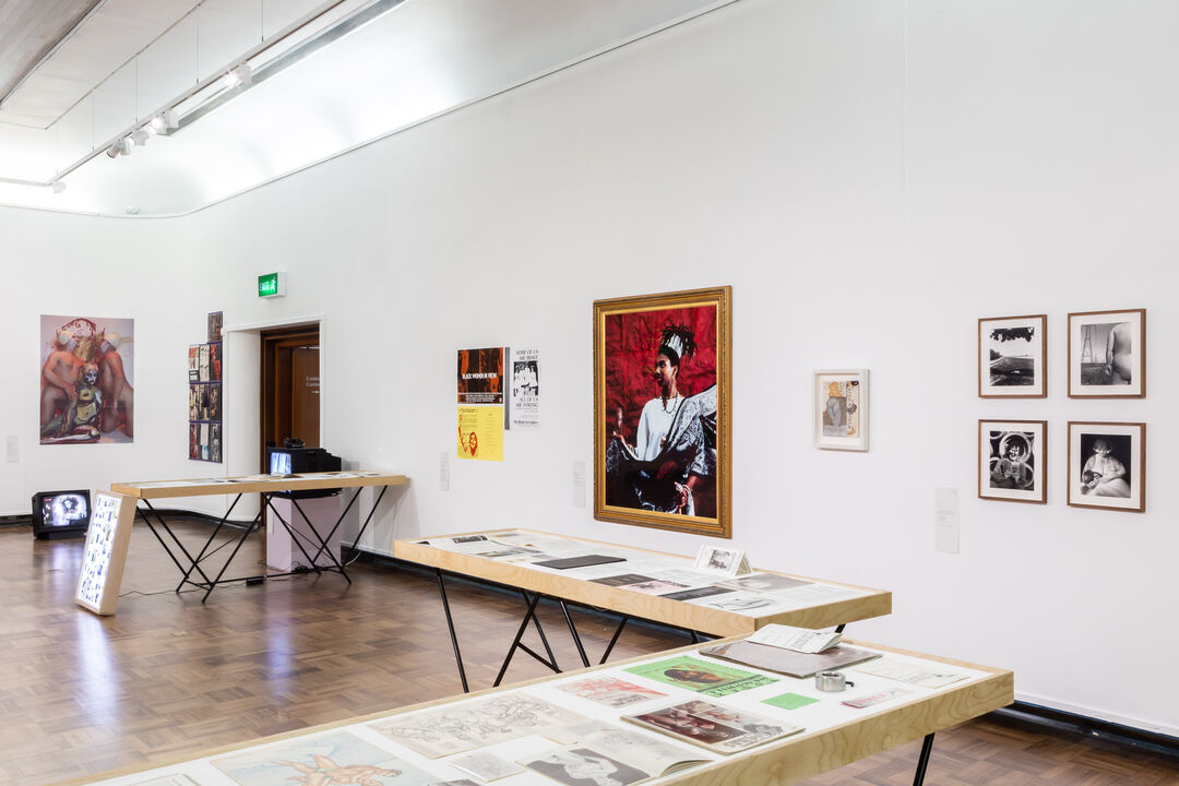 Exhibition view, pictures and tables with artworks