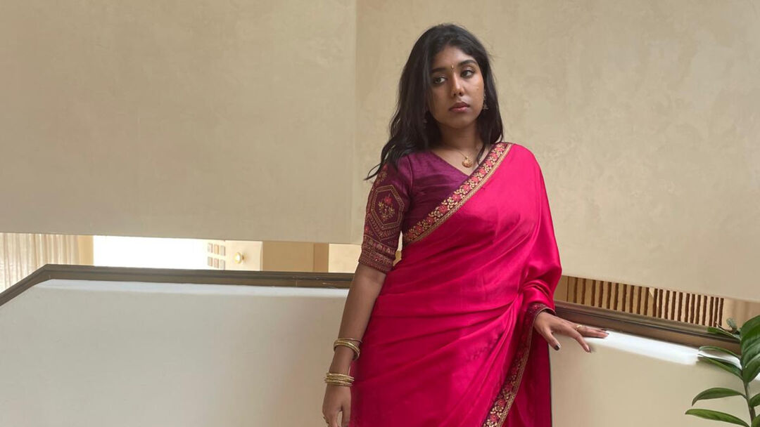 Sandra dressed in traditional attire leaning against a railing