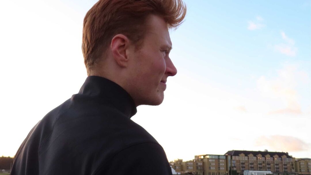 Jarrett Fiske's side profile, blue sky in the background.