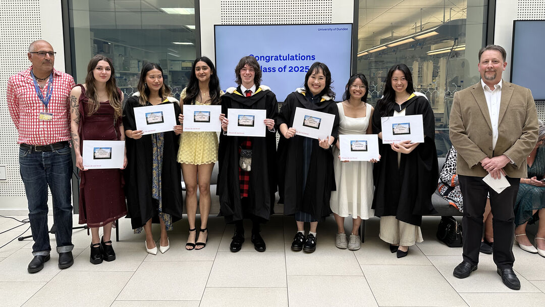 A group of people standing together smiling holding prize certificates