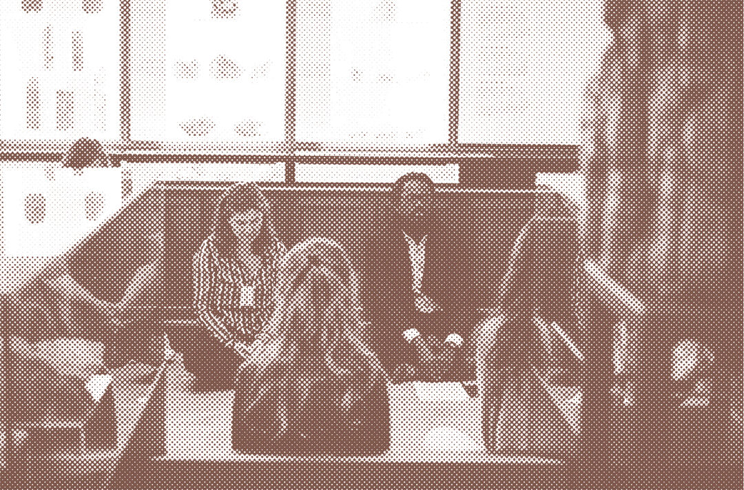 Sepia toned photograph of workshop participants meditating sat on the floor of a museum